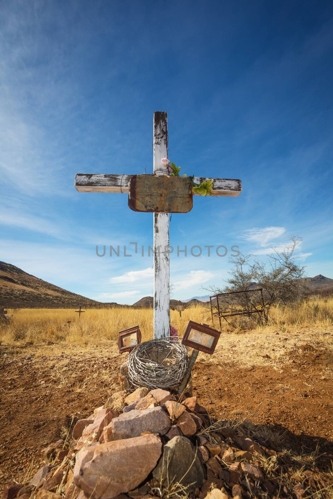 Old shallow stone grave with crucifix and blank frames