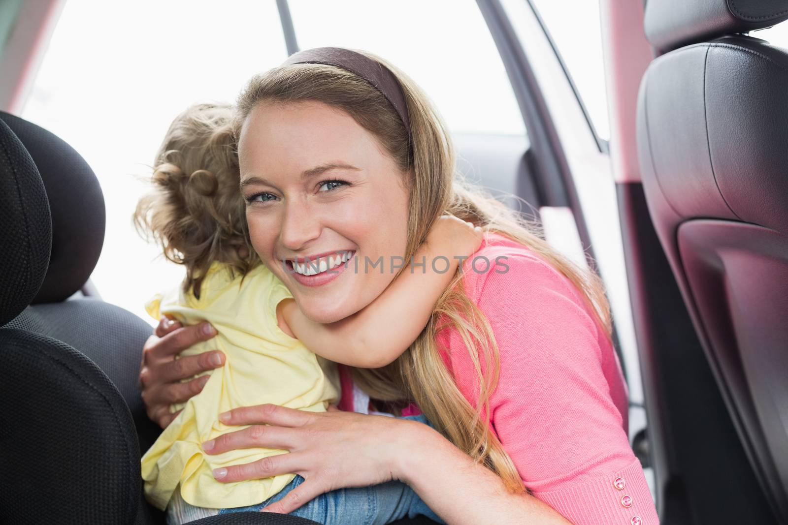 Mother securing her baby in the car seat by Wavebreakmedia