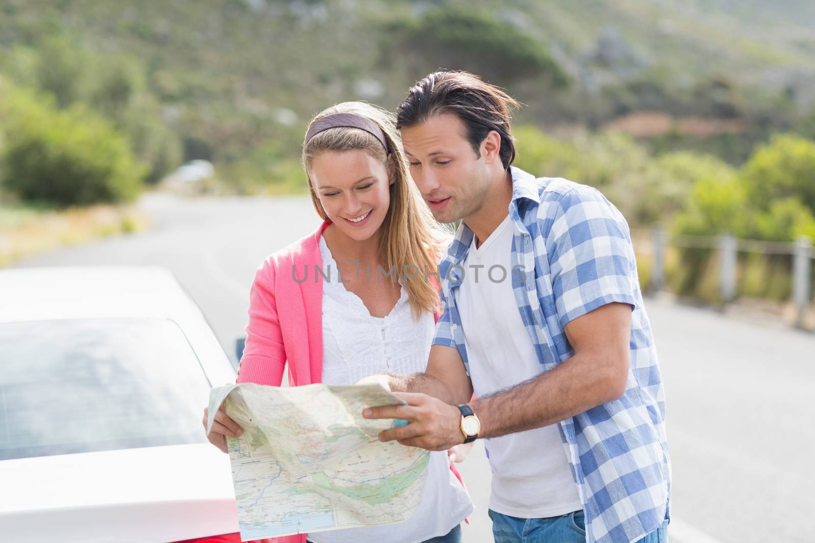 Couple looking at a map outside their car 