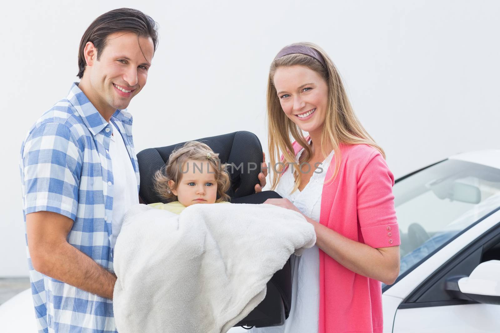 Parents carrying baby in his car seat by Wavebreakmedia