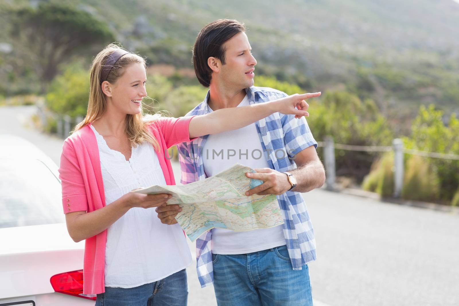 Couple looking at the map outside their car 