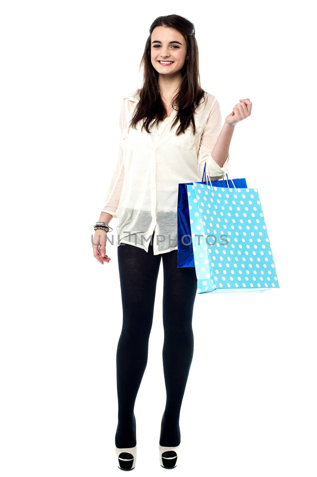 Trendy young girl posing with vibrant shopping bags