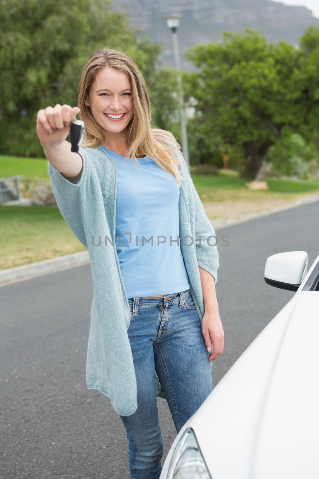 Young woman holding her key beside of her car 