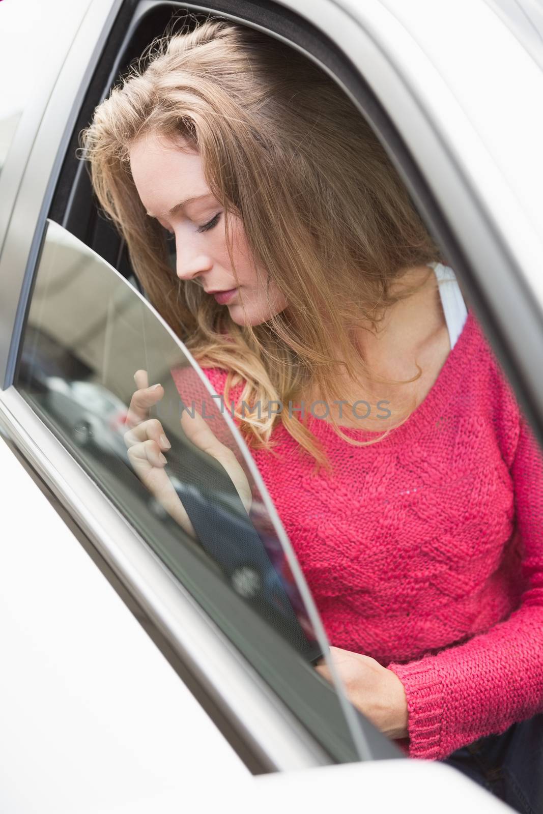 Young woman holding seat belt in her car