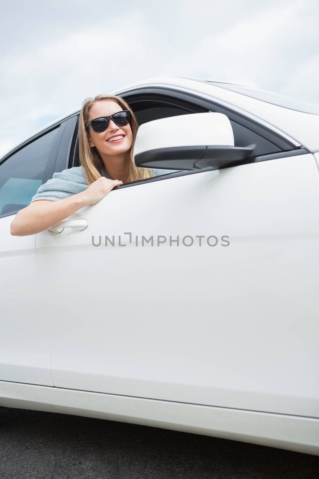 Young woman smiling at camera in her car