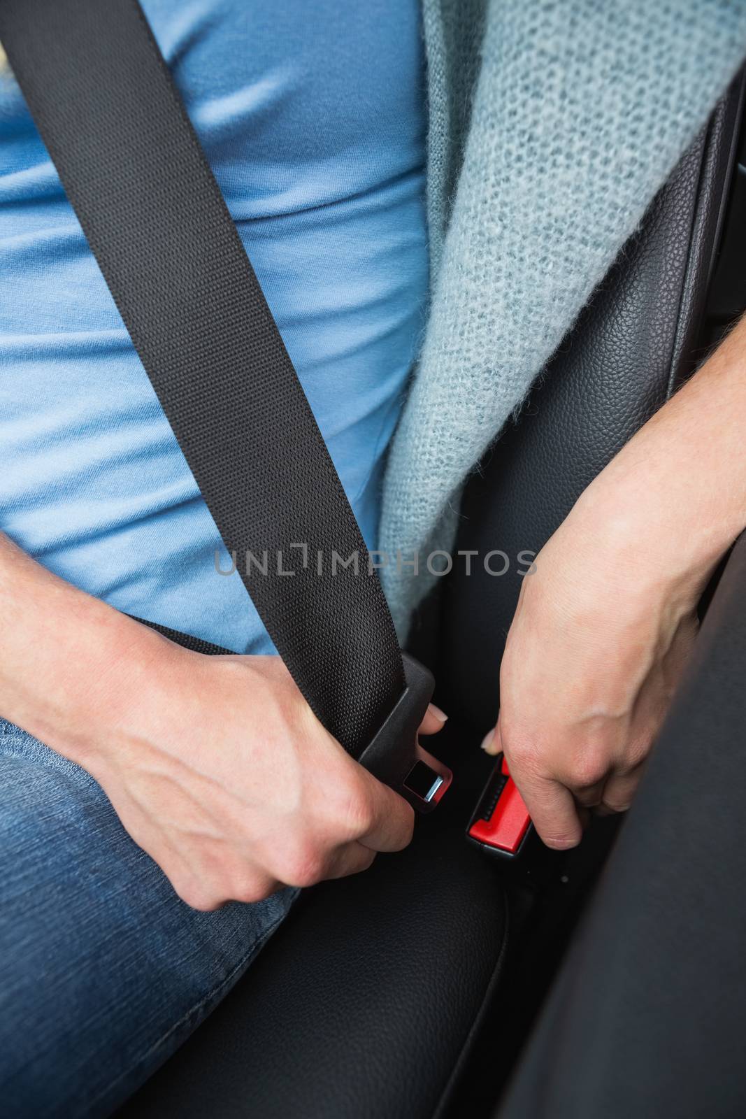 Woman putting on her seat belt  by Wavebreakmedia