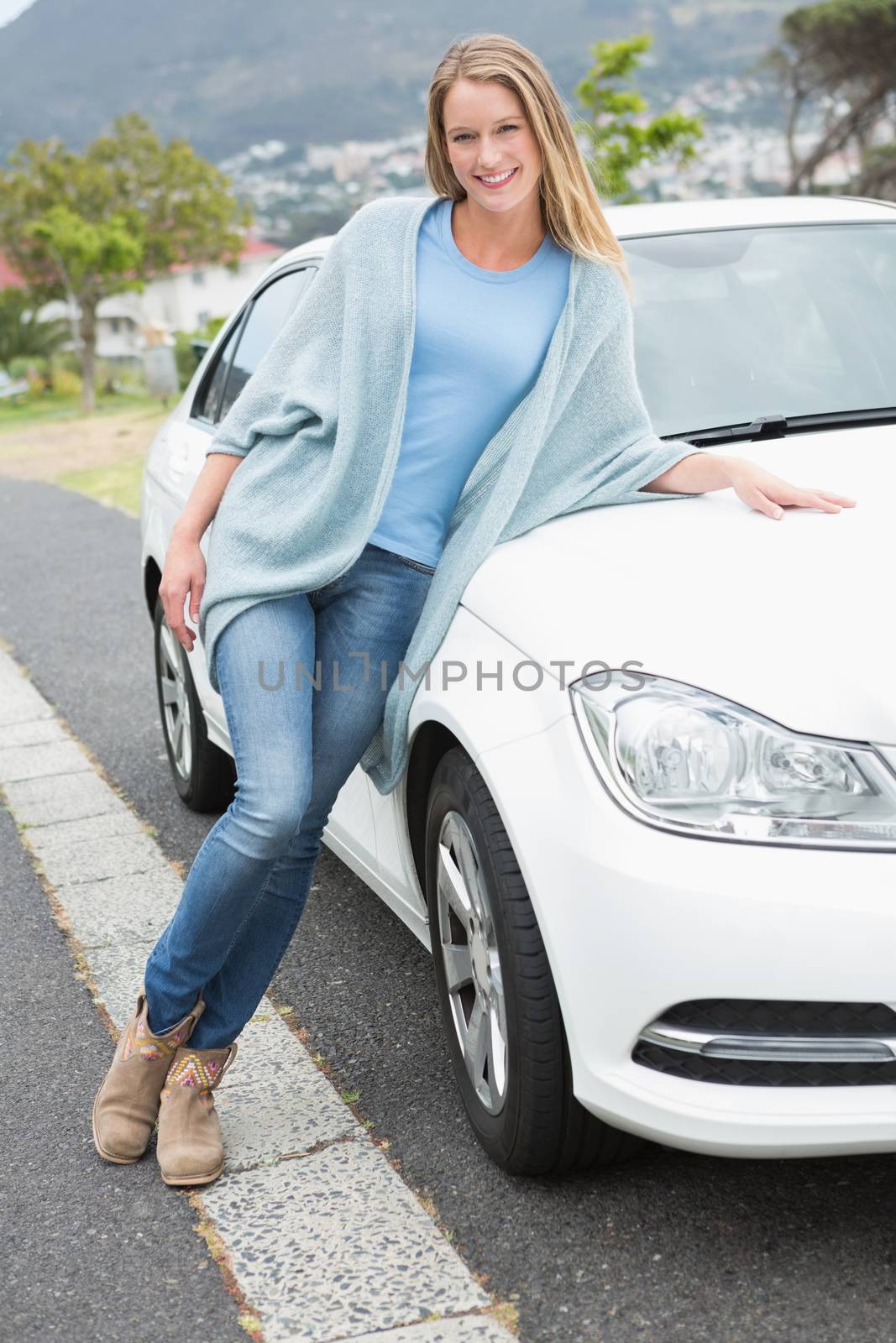 Young woman posing beside her car