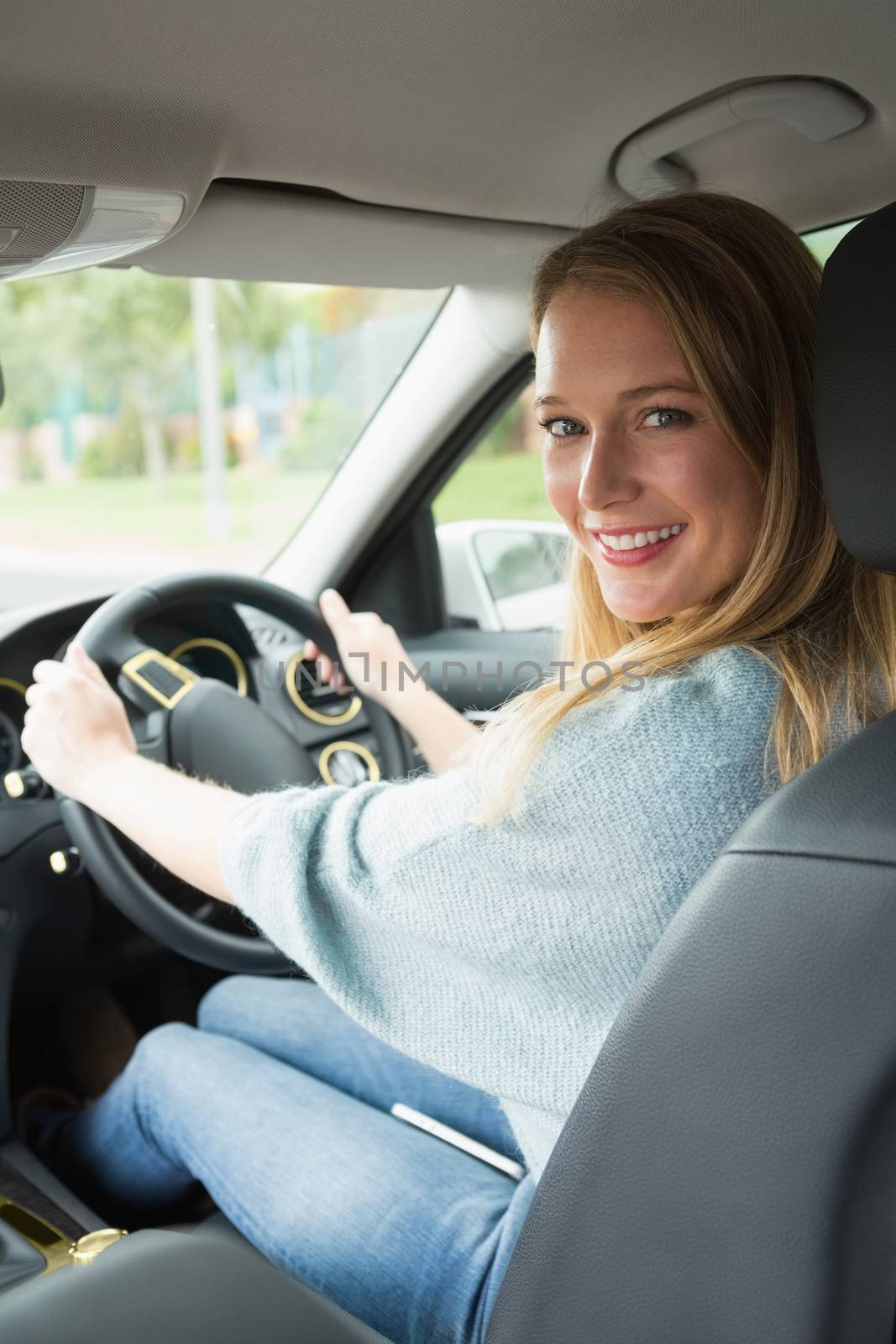 Young woman smiling while driving  by Wavebreakmedia