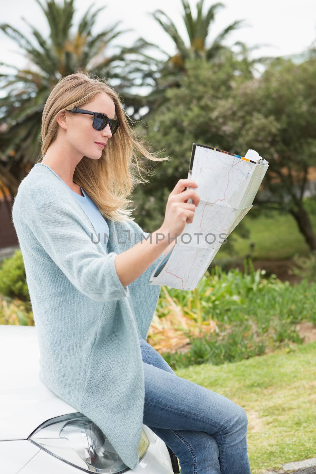 Young woman reading a map  by Wavebreakmedia