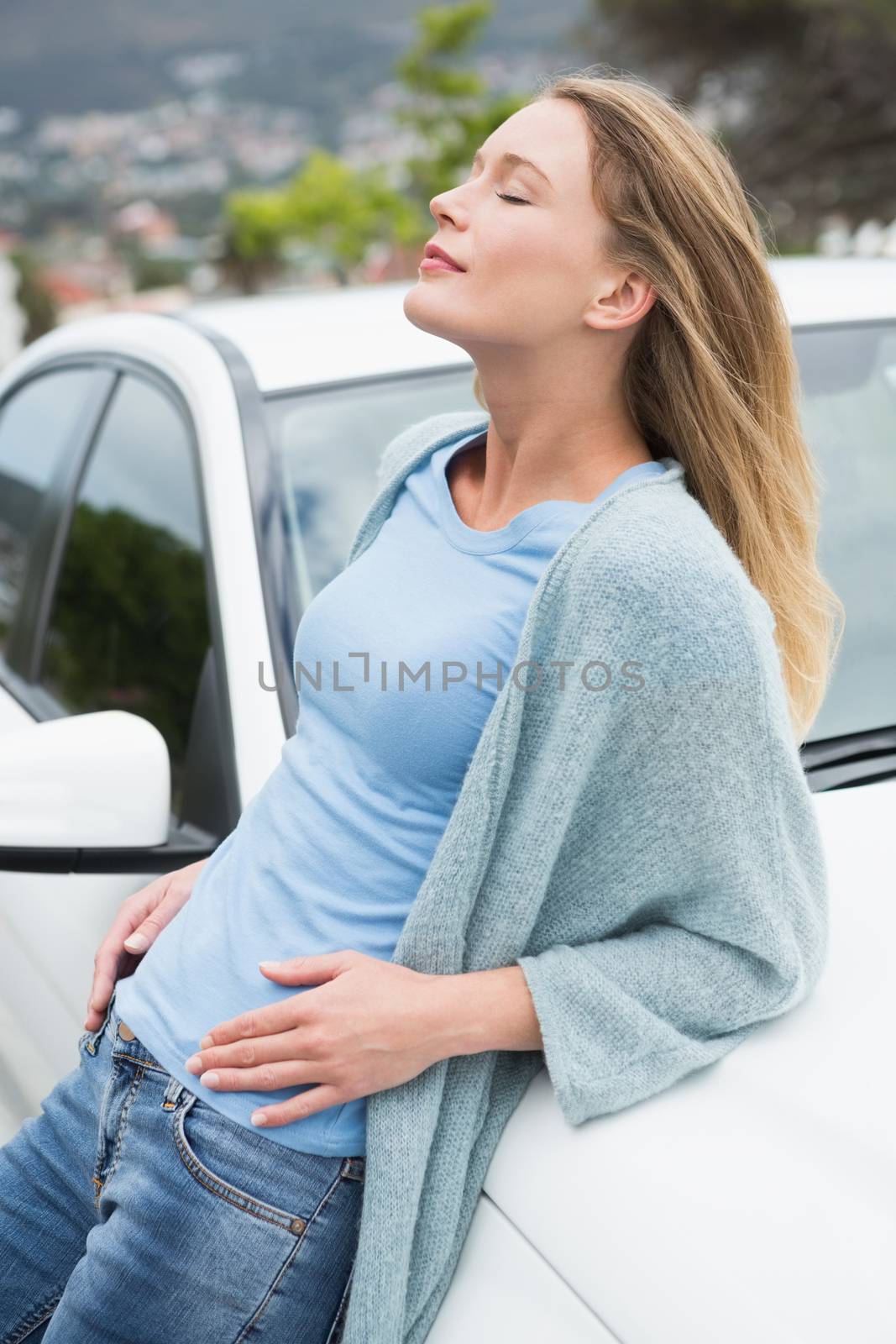 Young woman leaning on her car