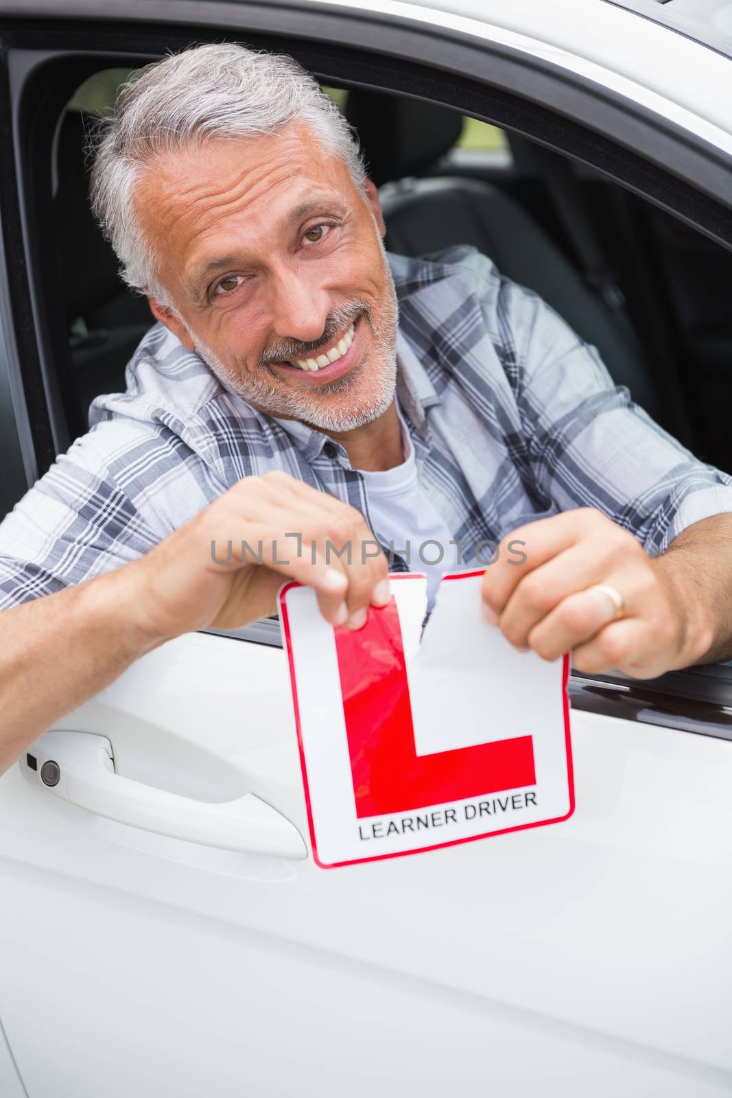 Driver smiling and tearing l plate  by Wavebreakmedia