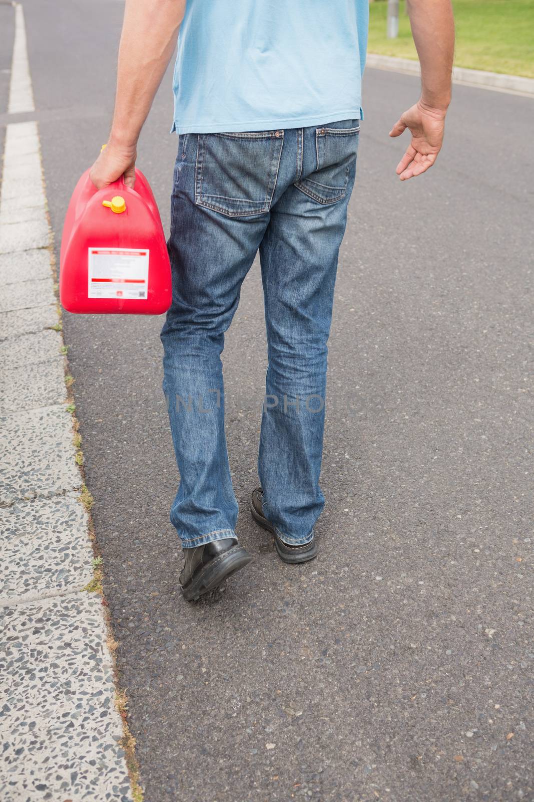 Man bringing petrol canister to a broken down car in the street