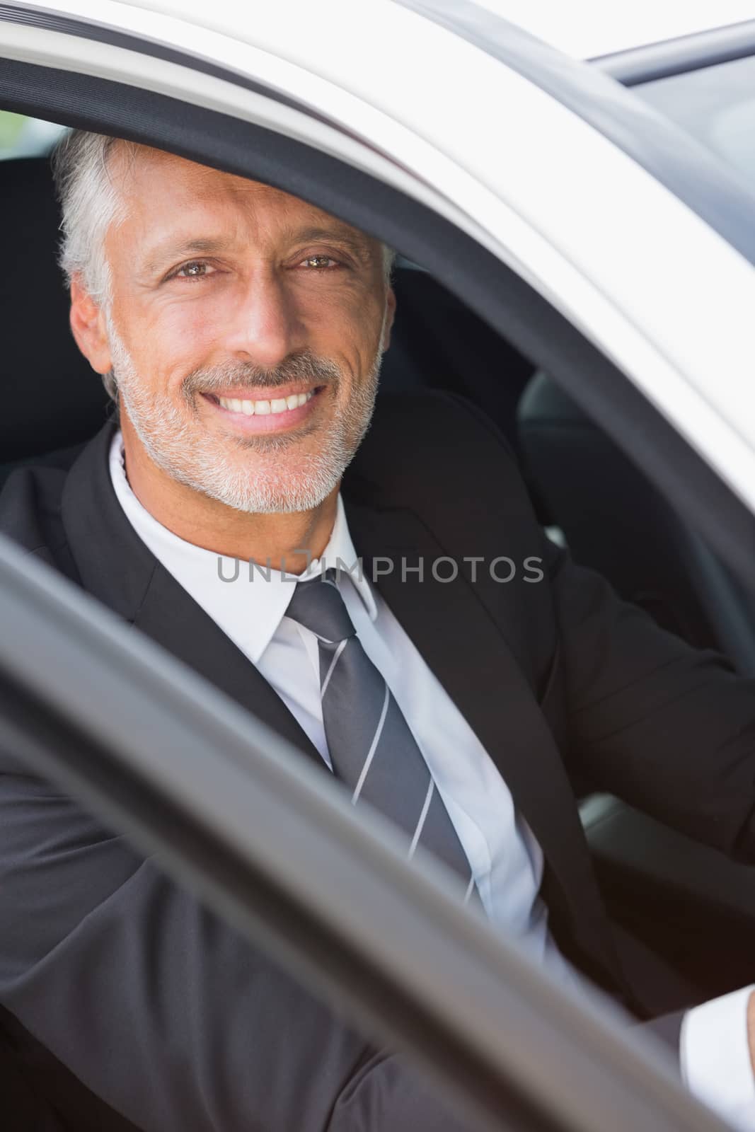 Businessman sitting in drivers seat in his car