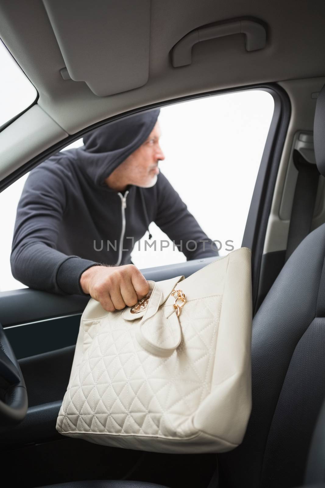 Thief breaking into car and stealing hand bag in broad daylight