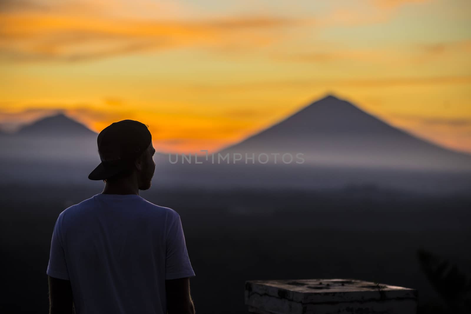 Man and Volcano Agung as Background at Sunrise Time,Bali,Indonesia.