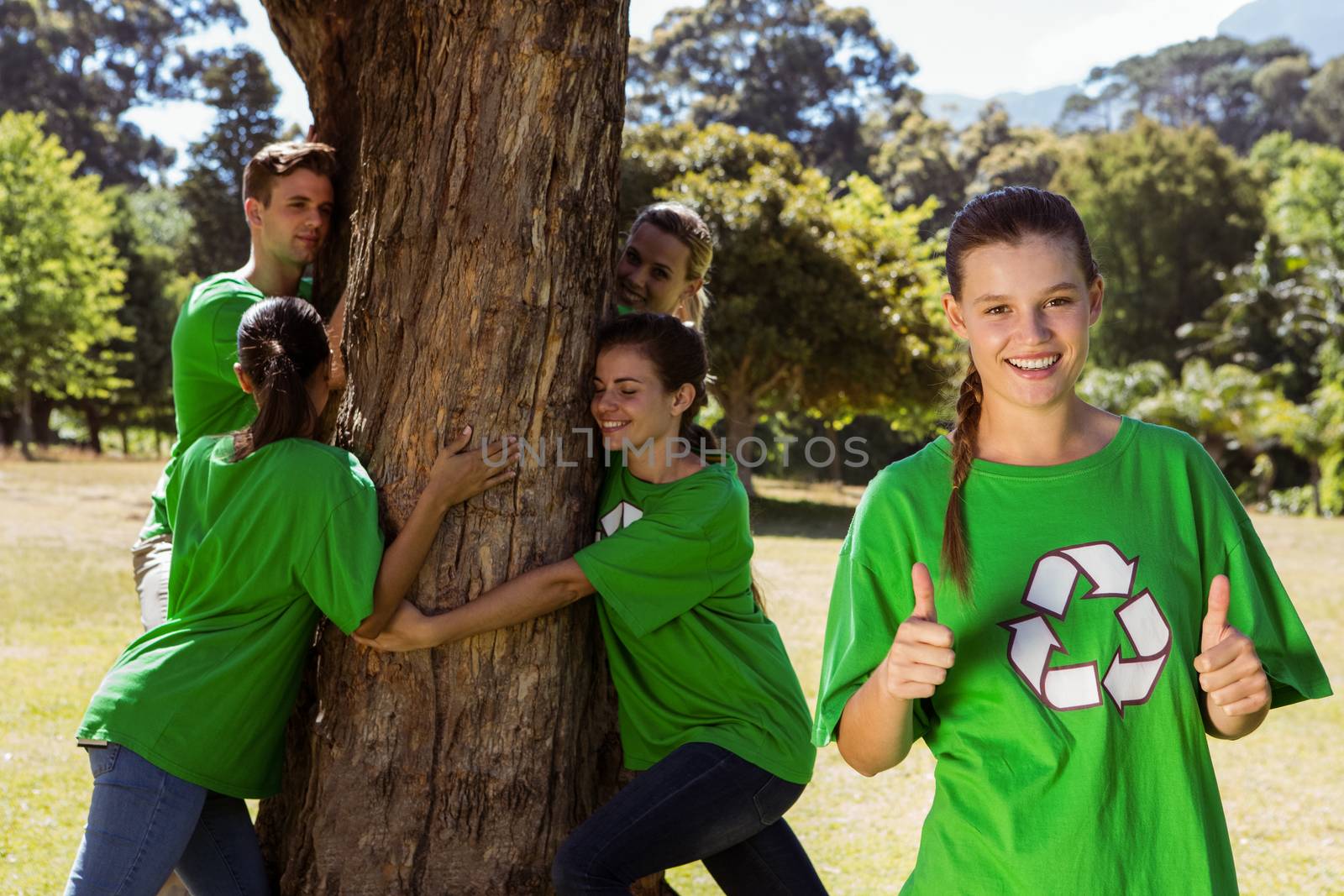 Environmental activists hugging a tree in the park on a sunny day
