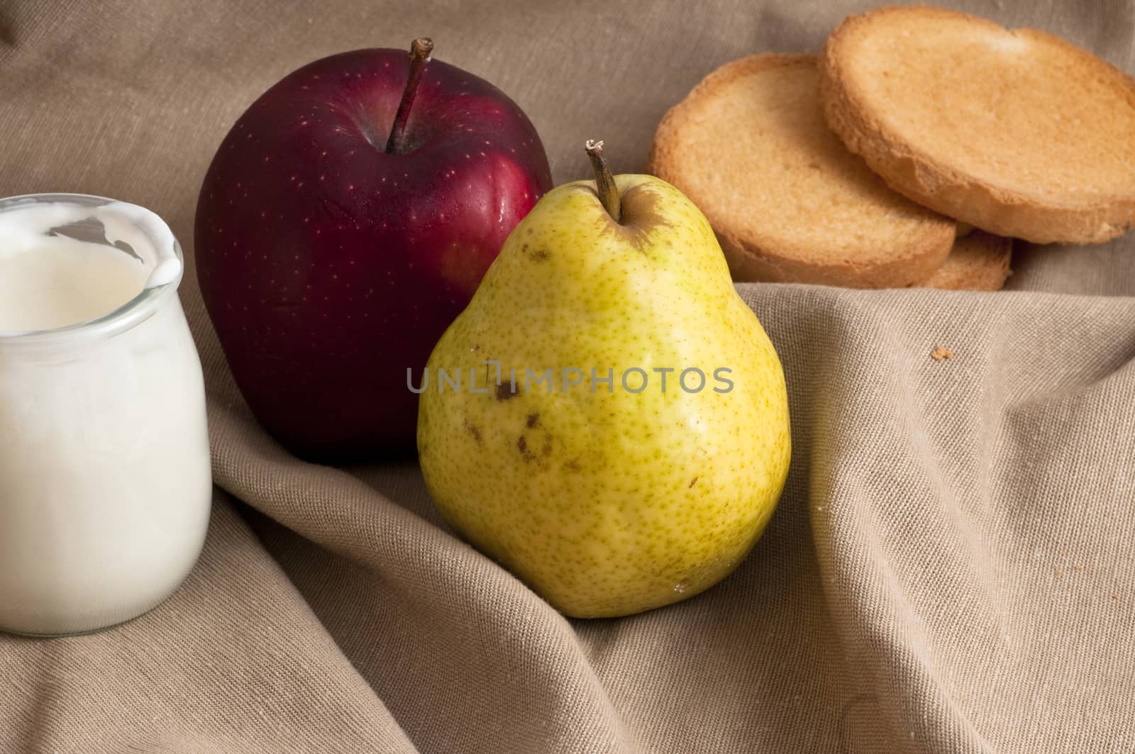 breakfast served with yogurt, apple and pear on a towel