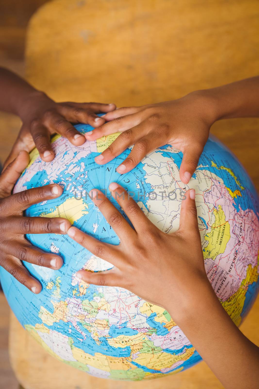 Close up of hands on globe in classroom