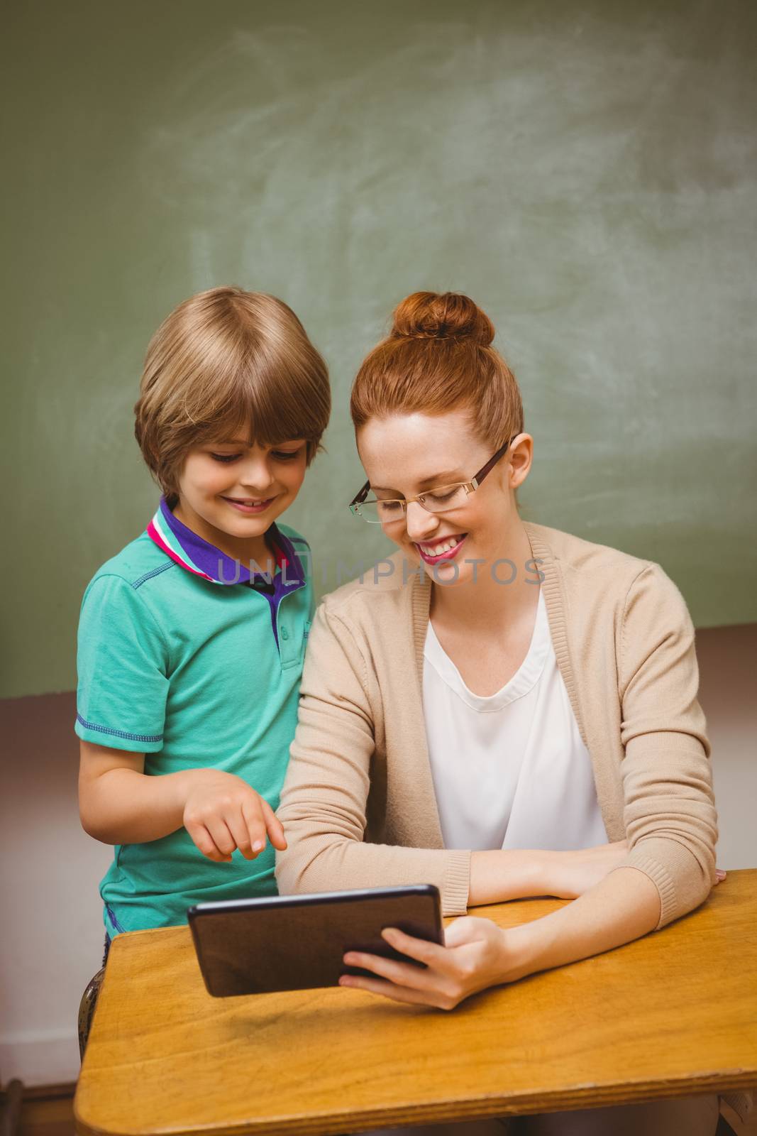 Portrait of female teacher and boy using digital tablet in the classroom