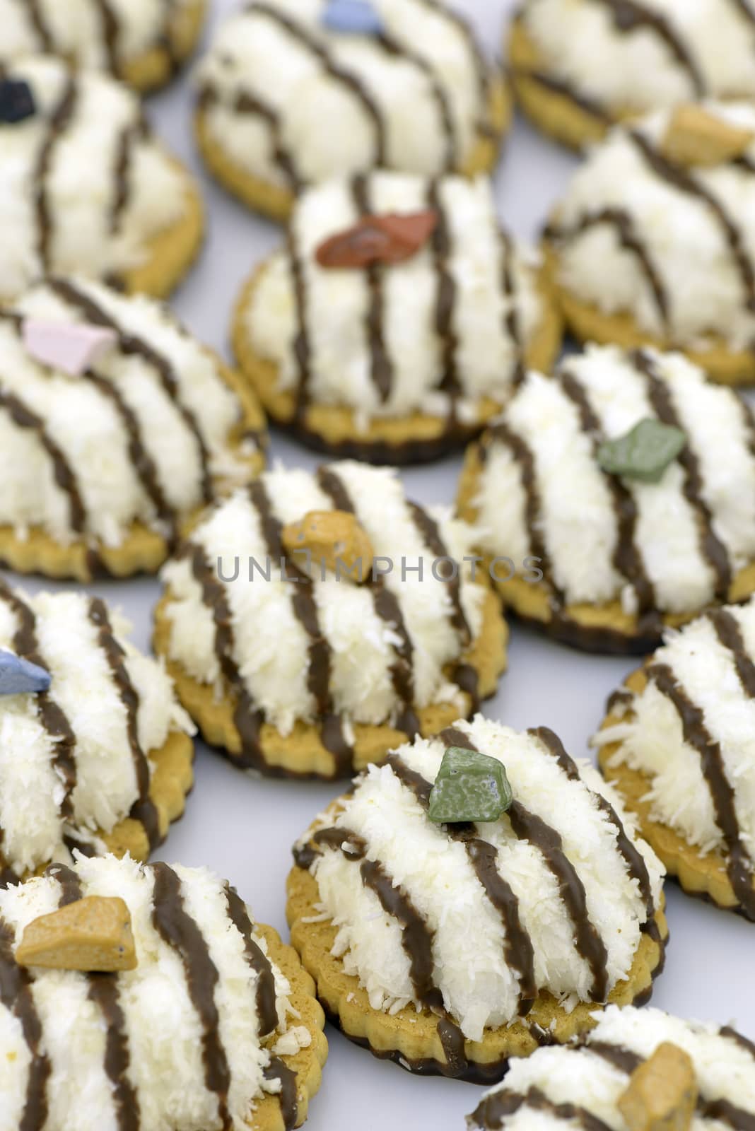 Several coconut cookies with chocolate stripes decorated with chocolate pebble
