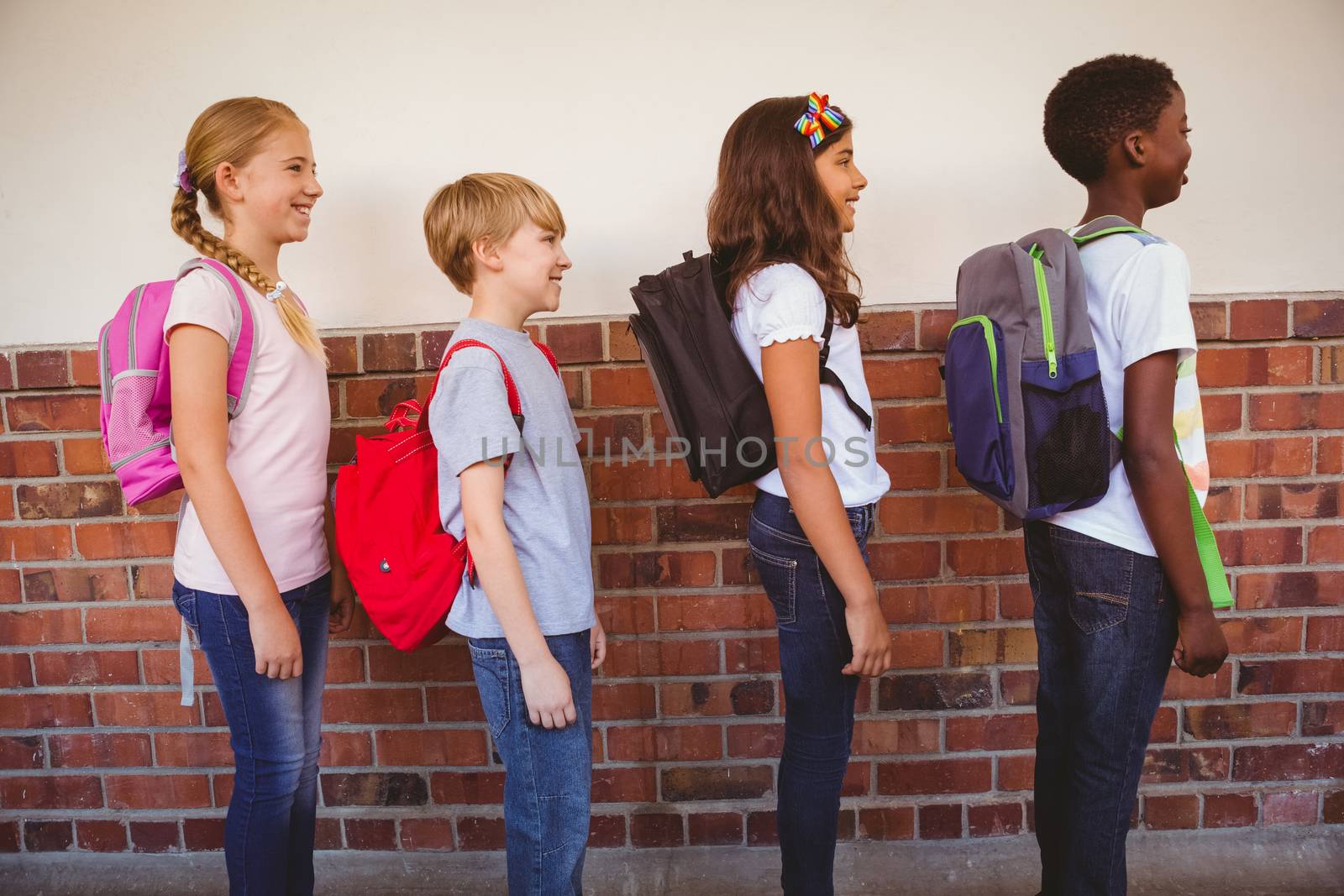 School kids standing in school corridor by Wavebreakmedia