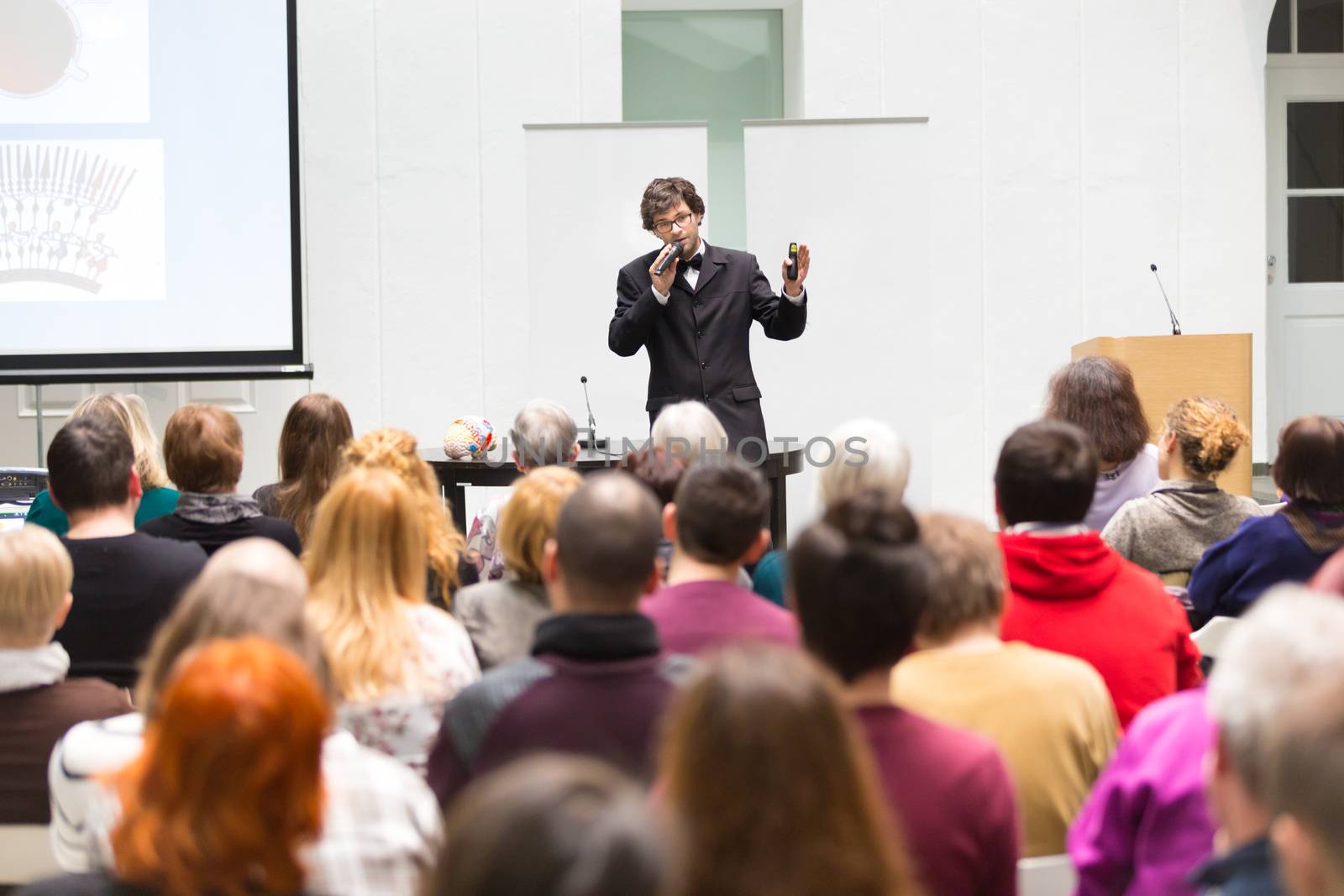 Speaker Giving a Talk at Business Meeting. Audience in the conference hall. Business and Entrepreneurship. Copy space on white board.