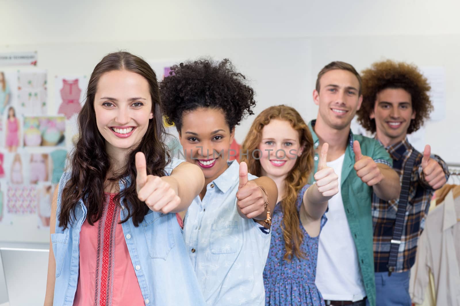 Portrait of confident and attractive fashion designers gesturing thumbs up