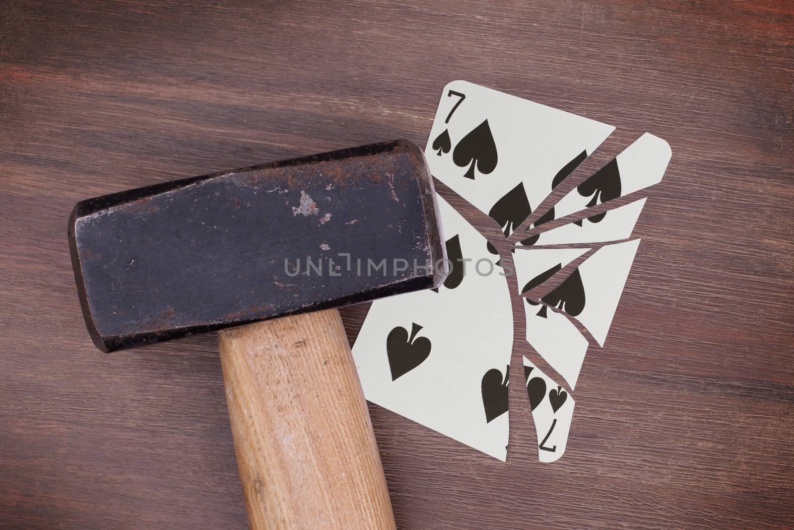 Hammer with a broken card, seven of spades by michaklootwijk
