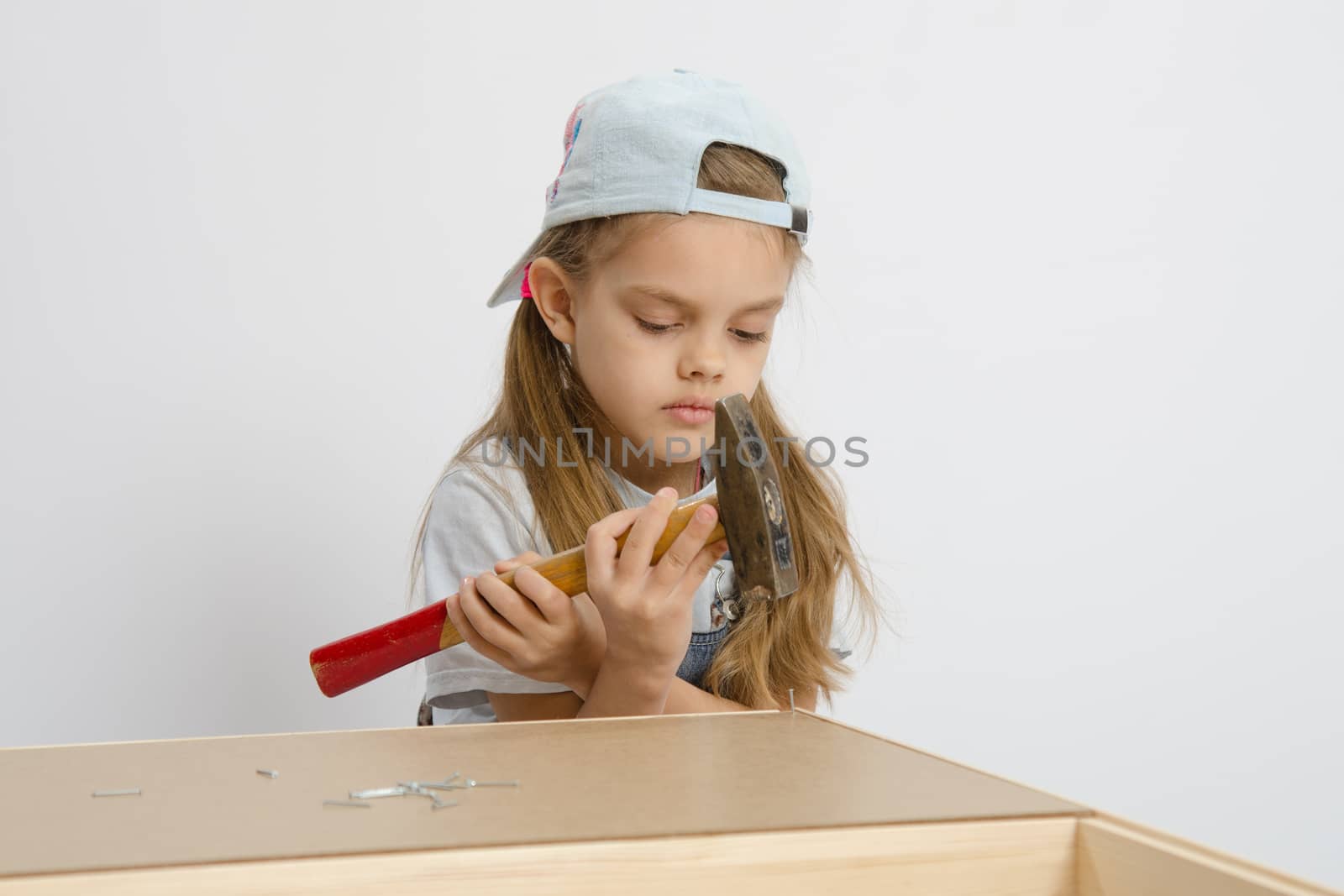 Six year old girl playing and collecting wooden cabinet