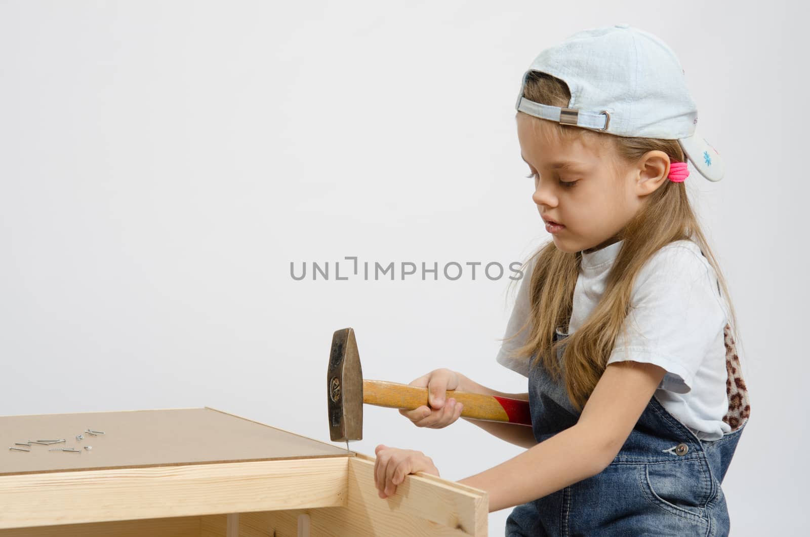 Six year old girl playing and collecting wooden cabinet