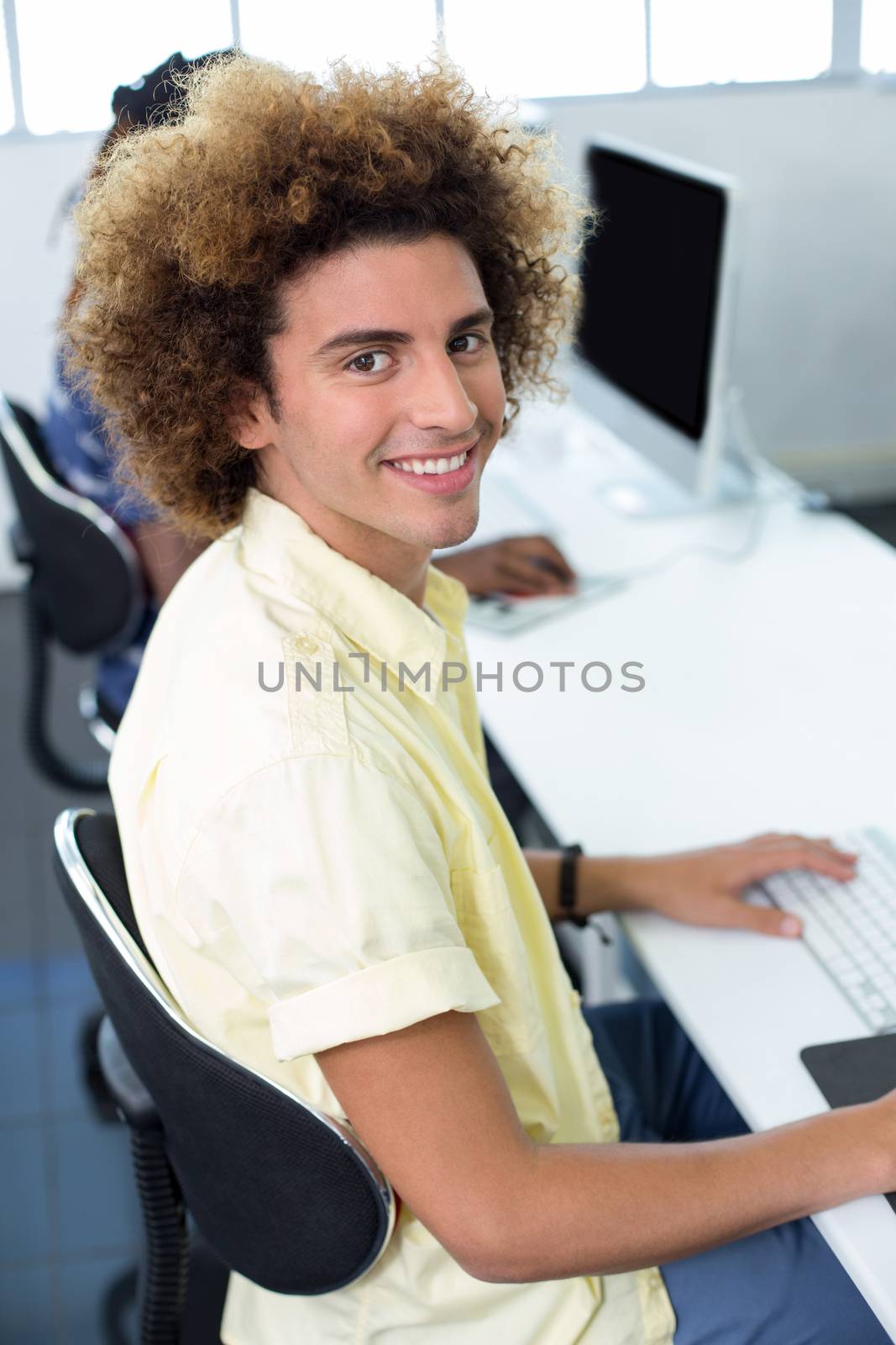 Male student smiling at camera in computer class