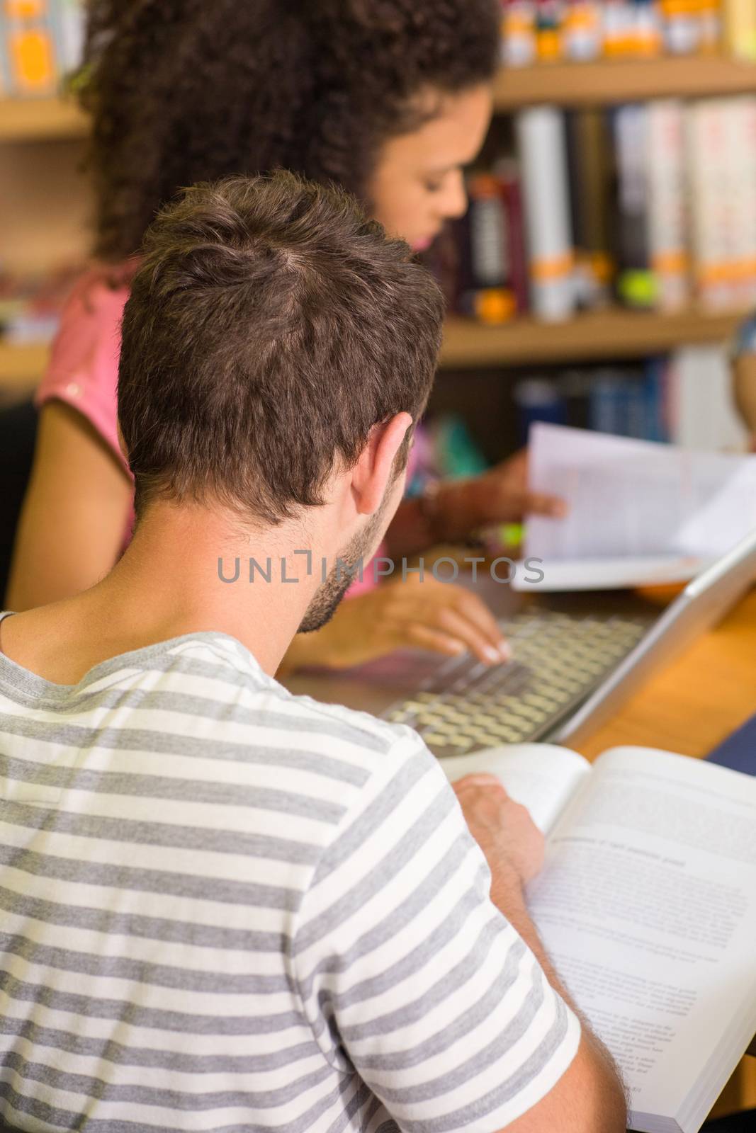 College students doing homework in the library