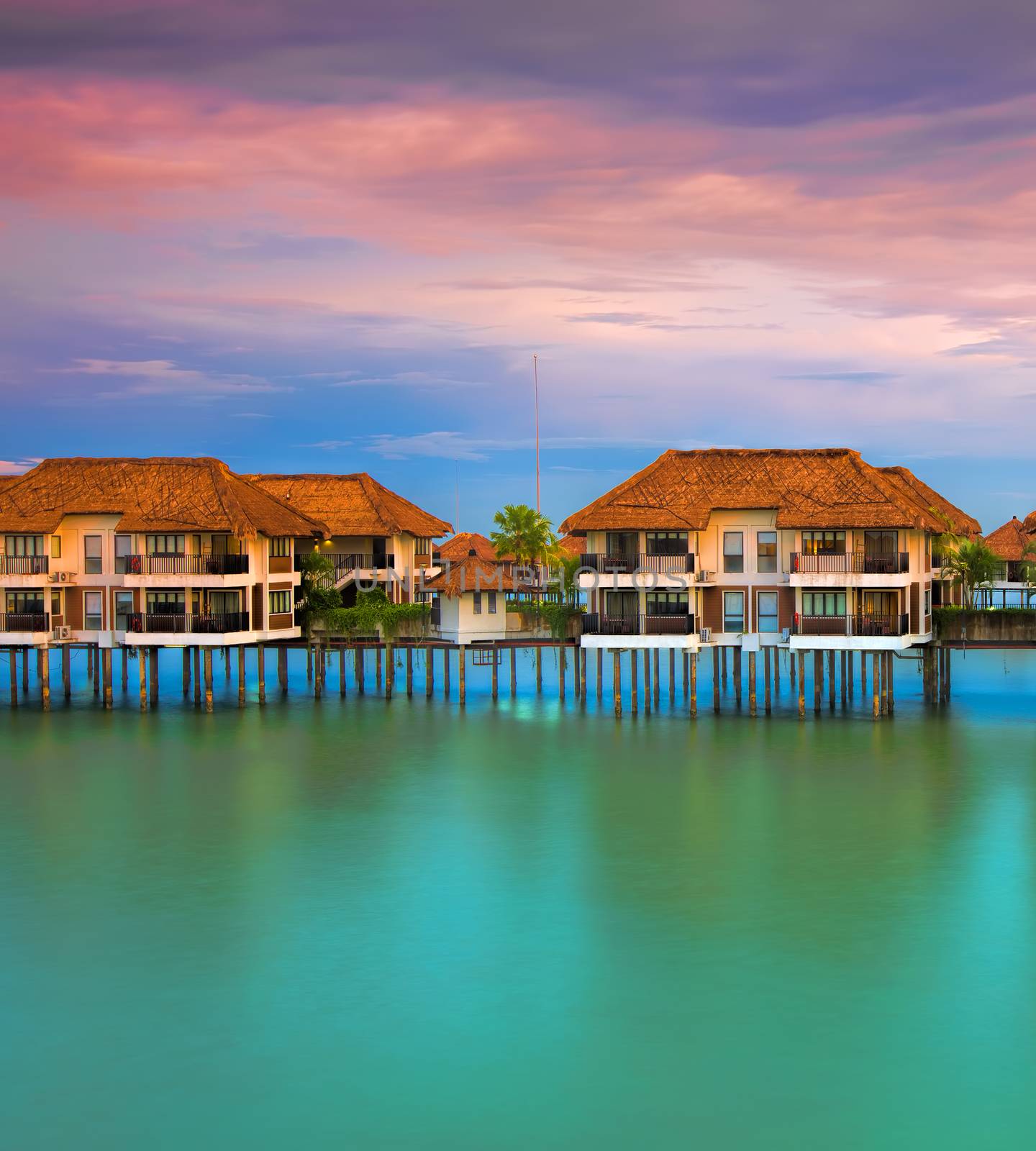Water villas making reflections in the ocean at sunset
