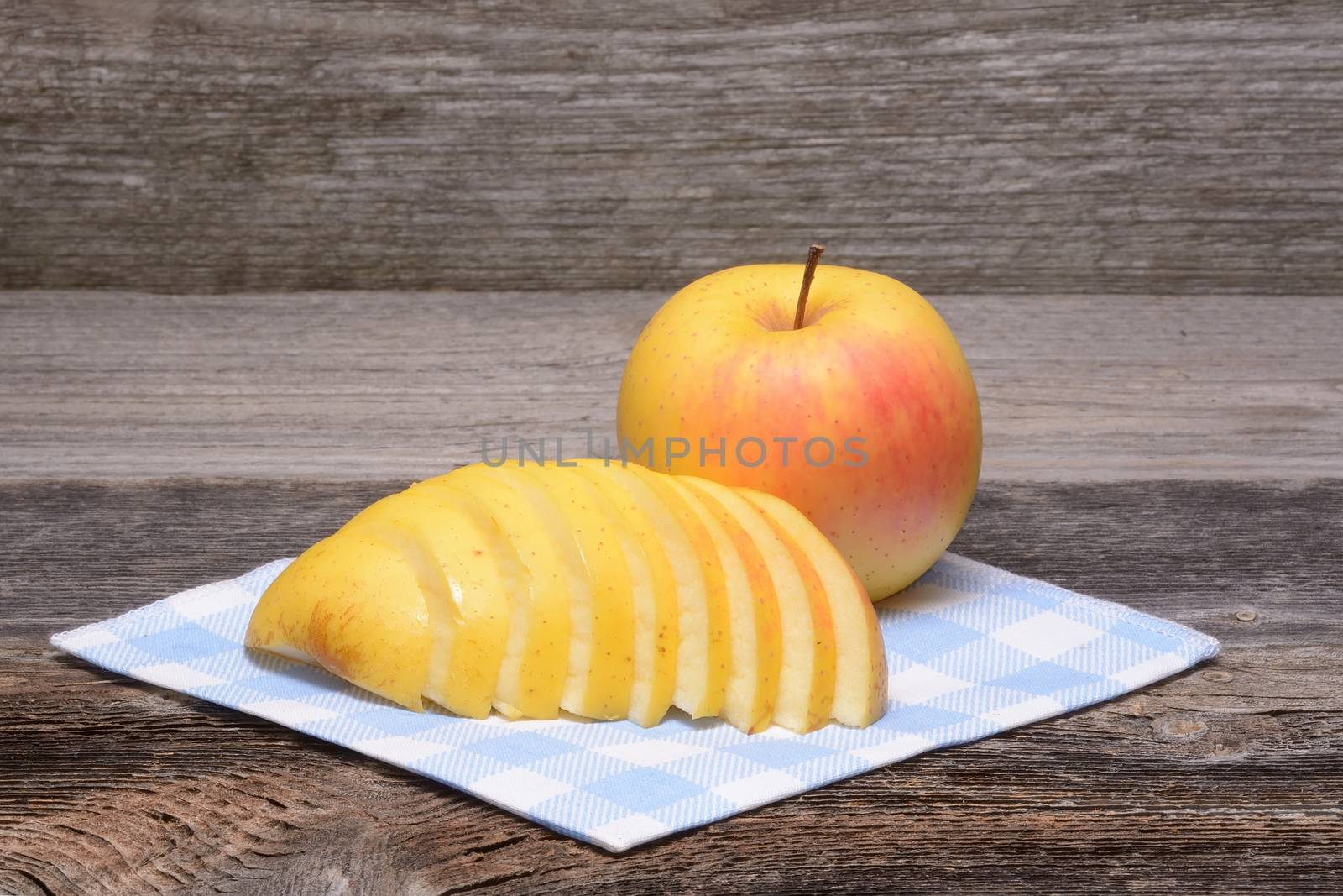 sliced apple on towel over wooden background by comet
