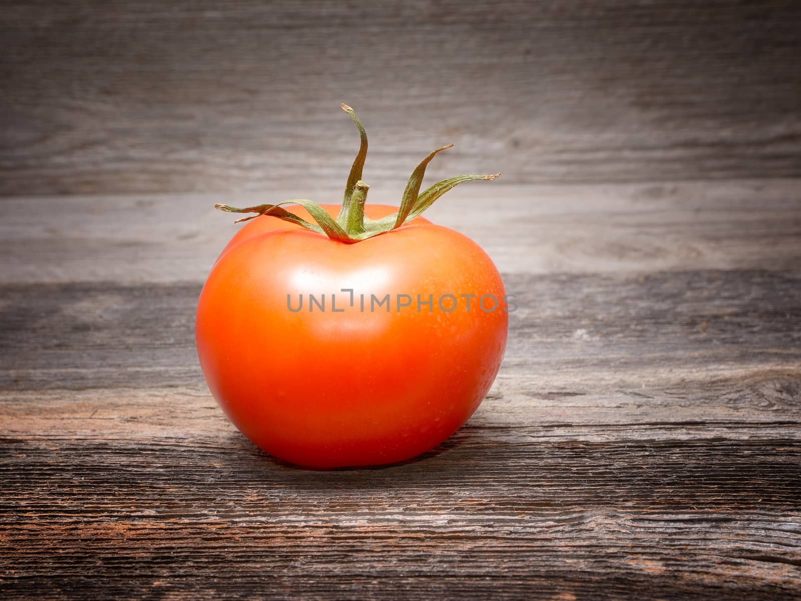 Fresh tomatoes on wooden background by comet