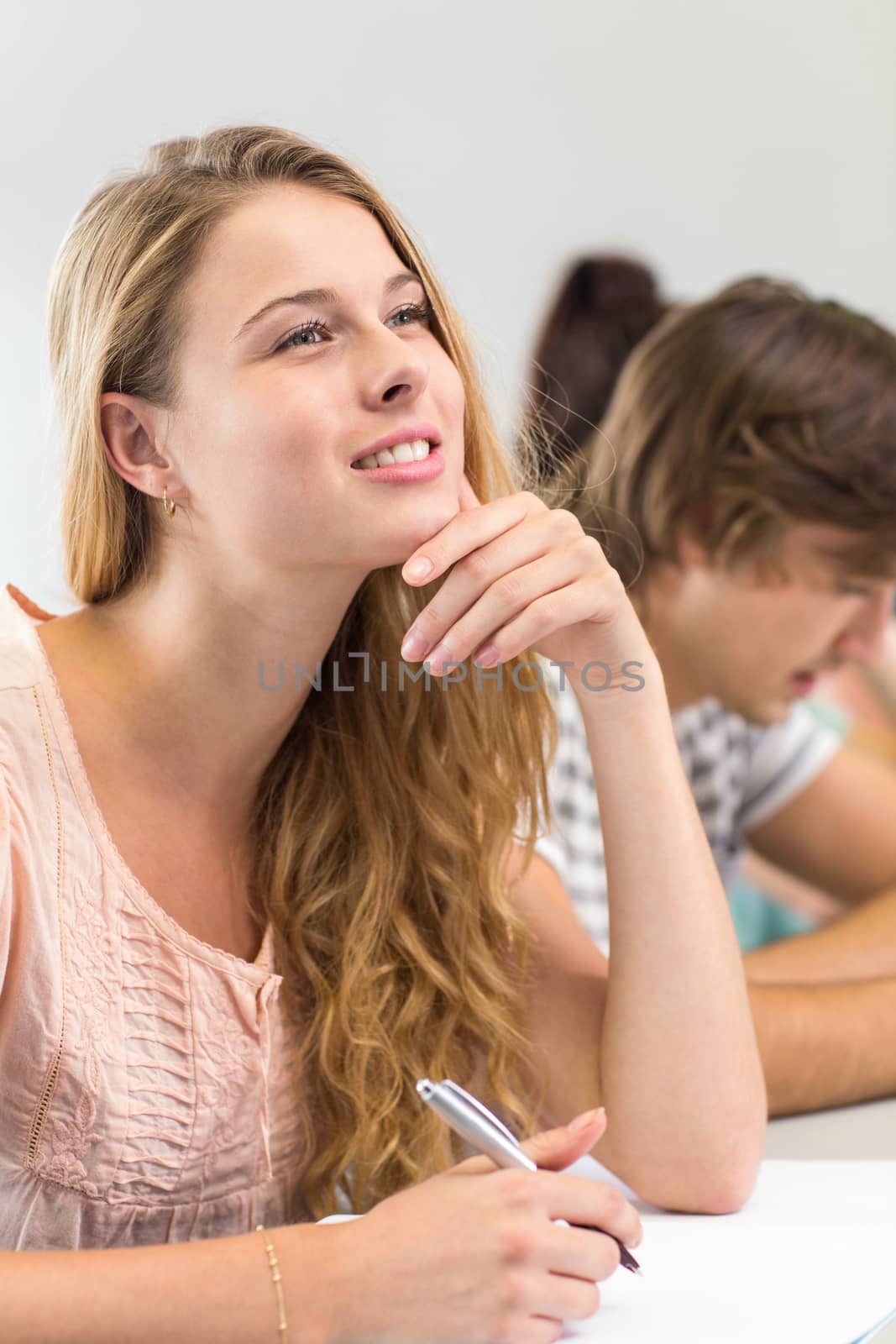 Female student writing notes in classroom by Wavebreakmedia