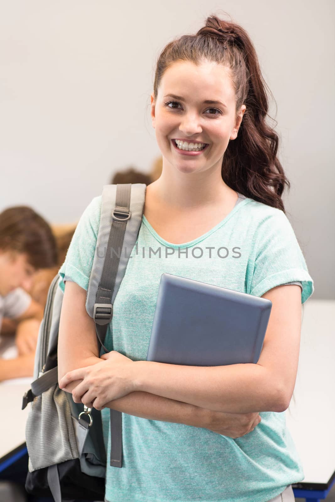 Happy female student holding digital tablet by Wavebreakmedia