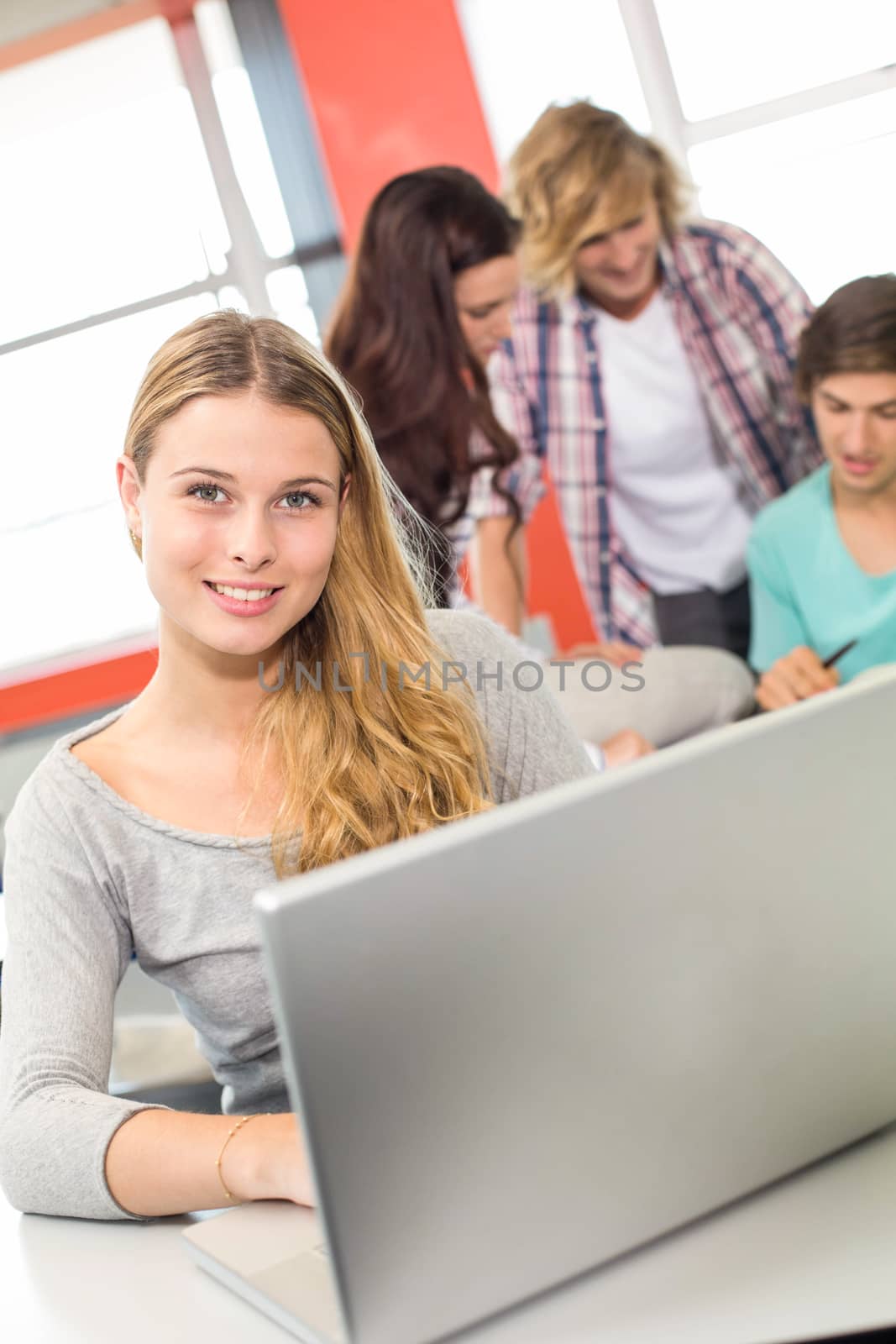 Female student using laptop in classroom by Wavebreakmedia