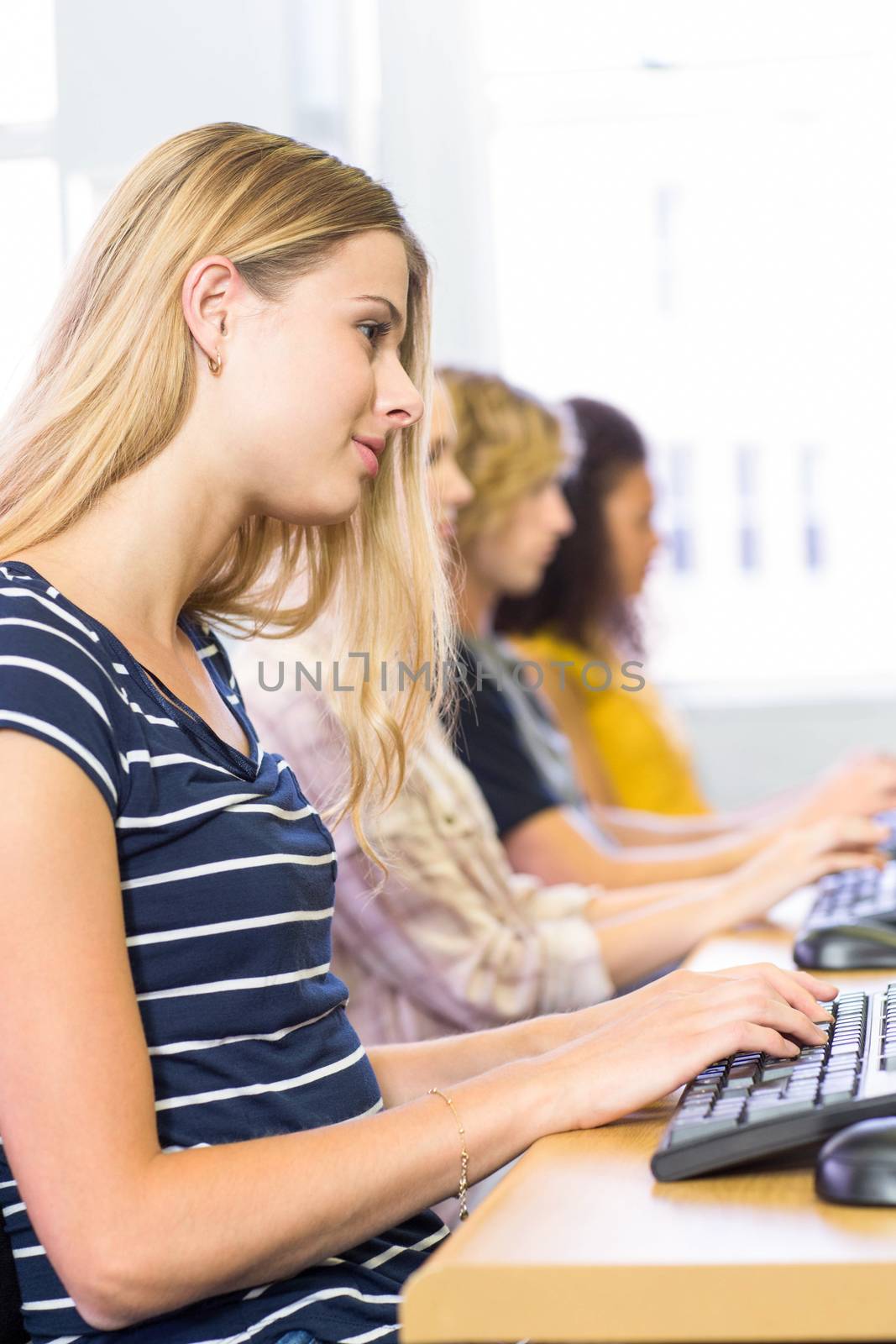 Students in row at computer class by Wavebreakmedia