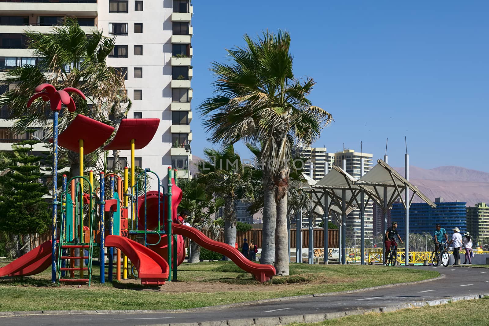 IQUIQUE, CHILE - FEBRUARY 10, 2015: Unidentified people on playground and bike lane along Cavancha beach on February 10, 2015 in Iquique, Chile. Iquique is a popular beach town and free port city in Northern Chile. 