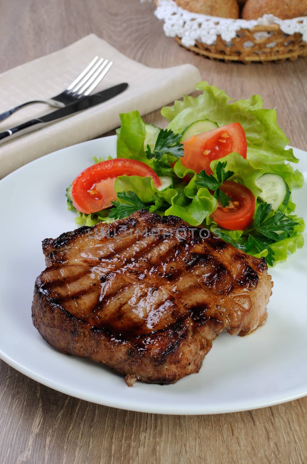 piece of juicy pork steak grilled with a salad