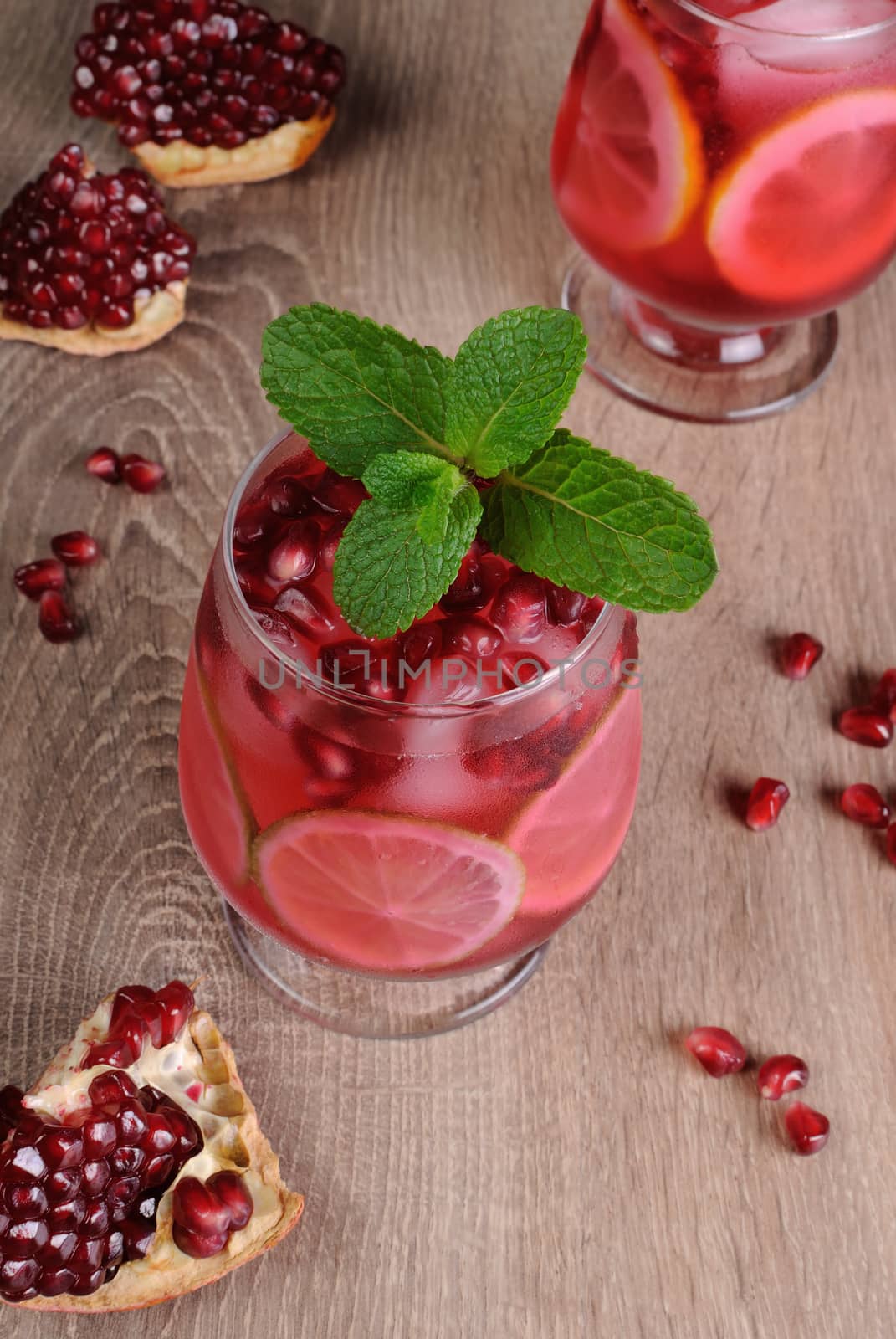 Pomegranate cocktail with slices of lime, mint and ice