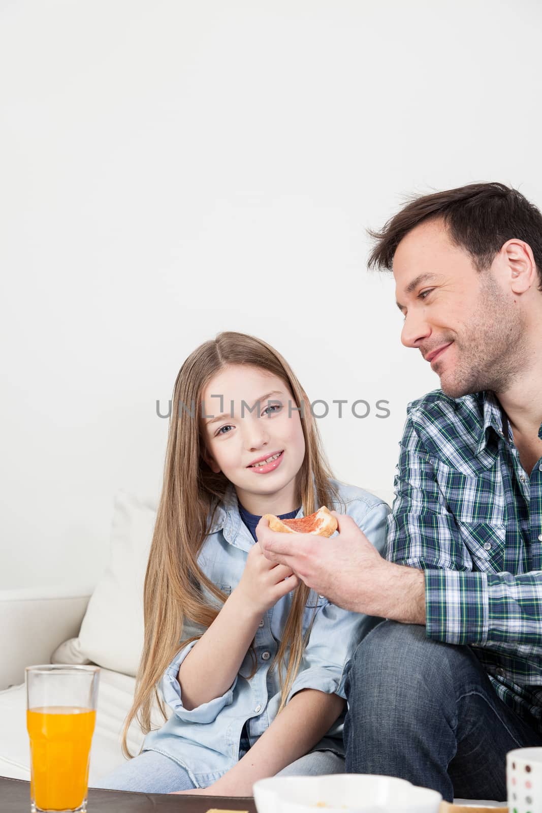 Girl having a breakfast with her father.