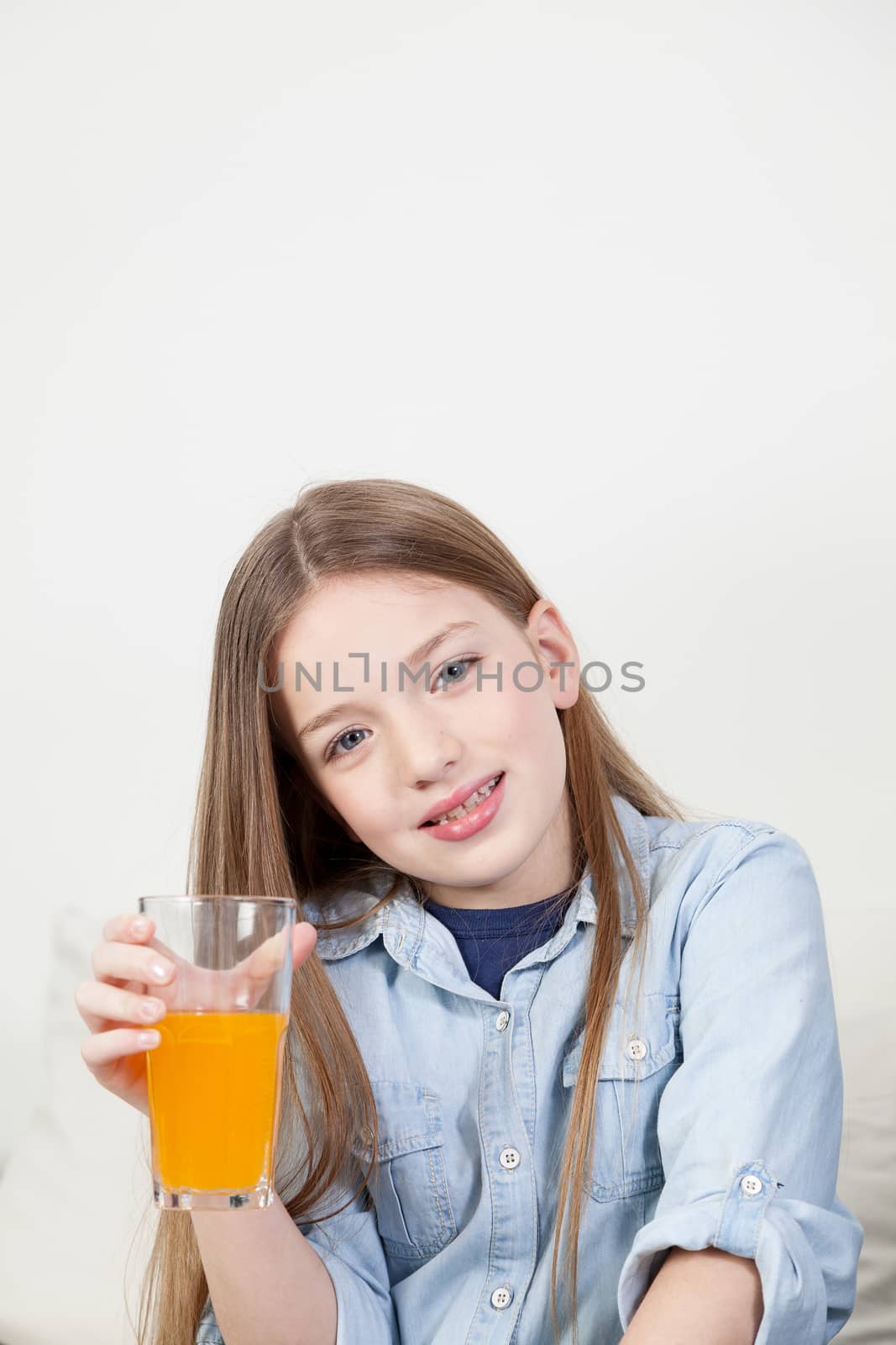 Pretty girl holding a glass with orange juice