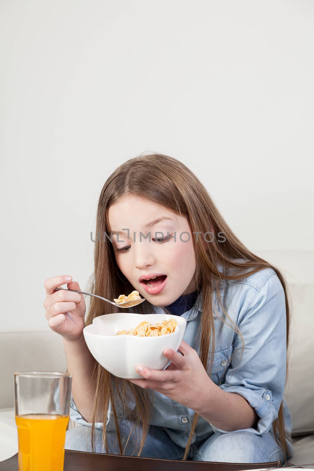 Little girl eating cereal in the breakfast