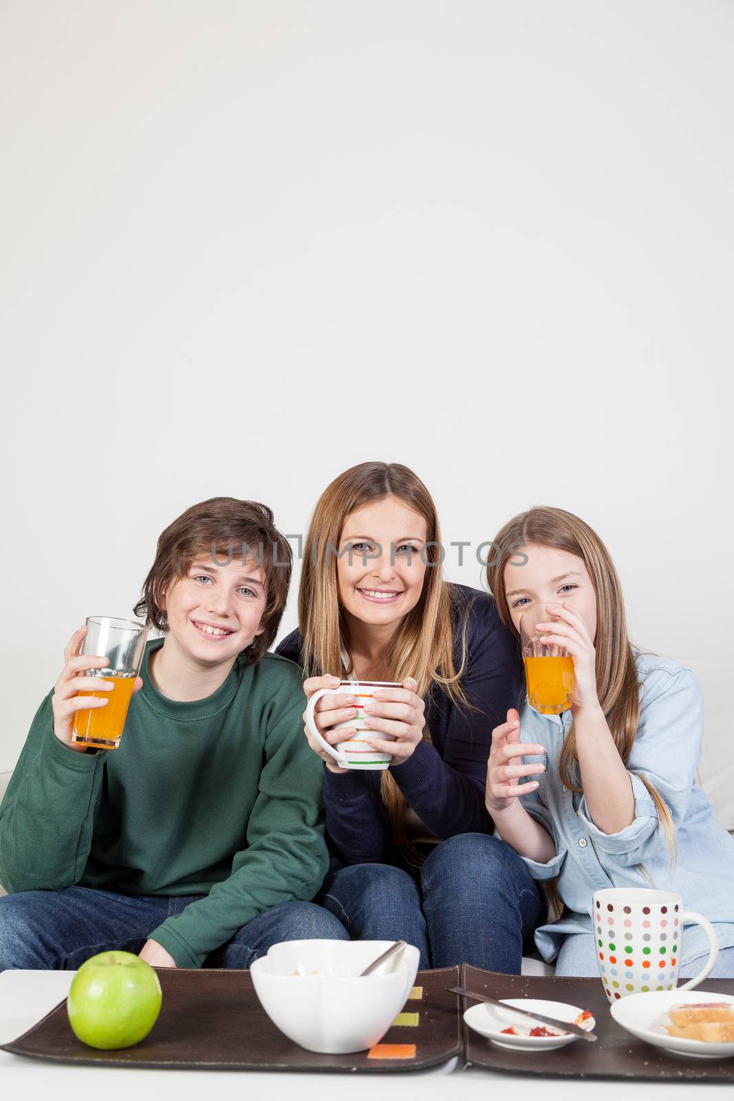 Mom with your two sons drinking juice in the breakfast by ifilms