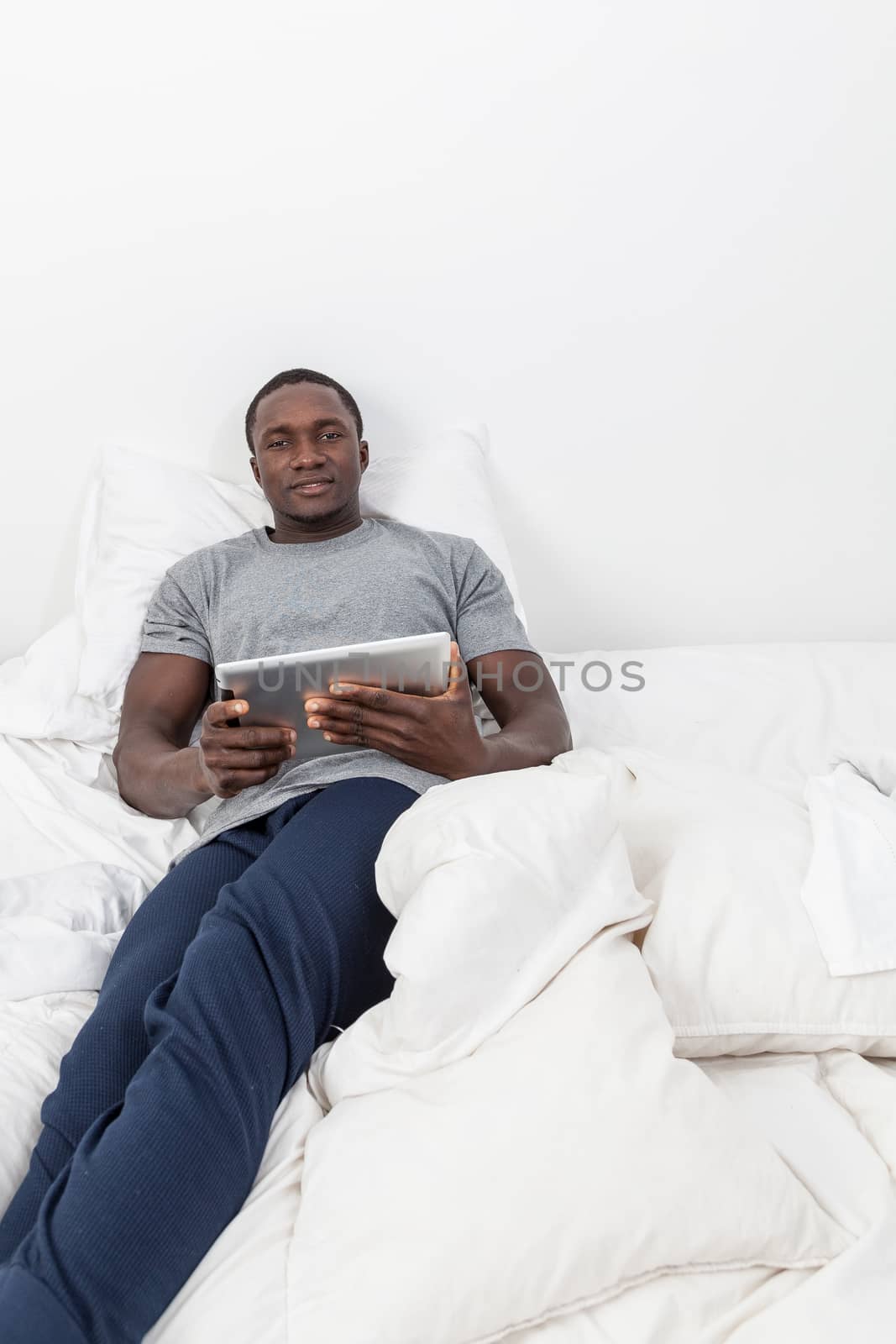 Man looking at camera and holding his tablet