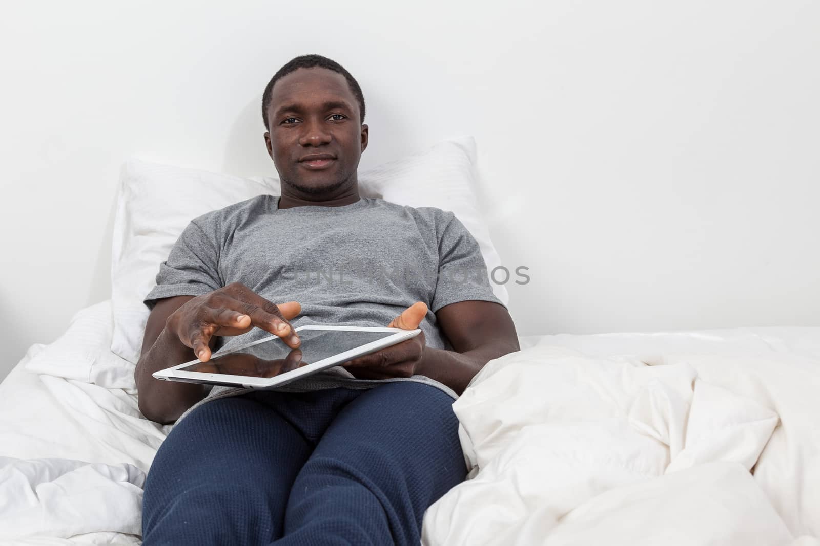 Man looking at camera and touching his tablet