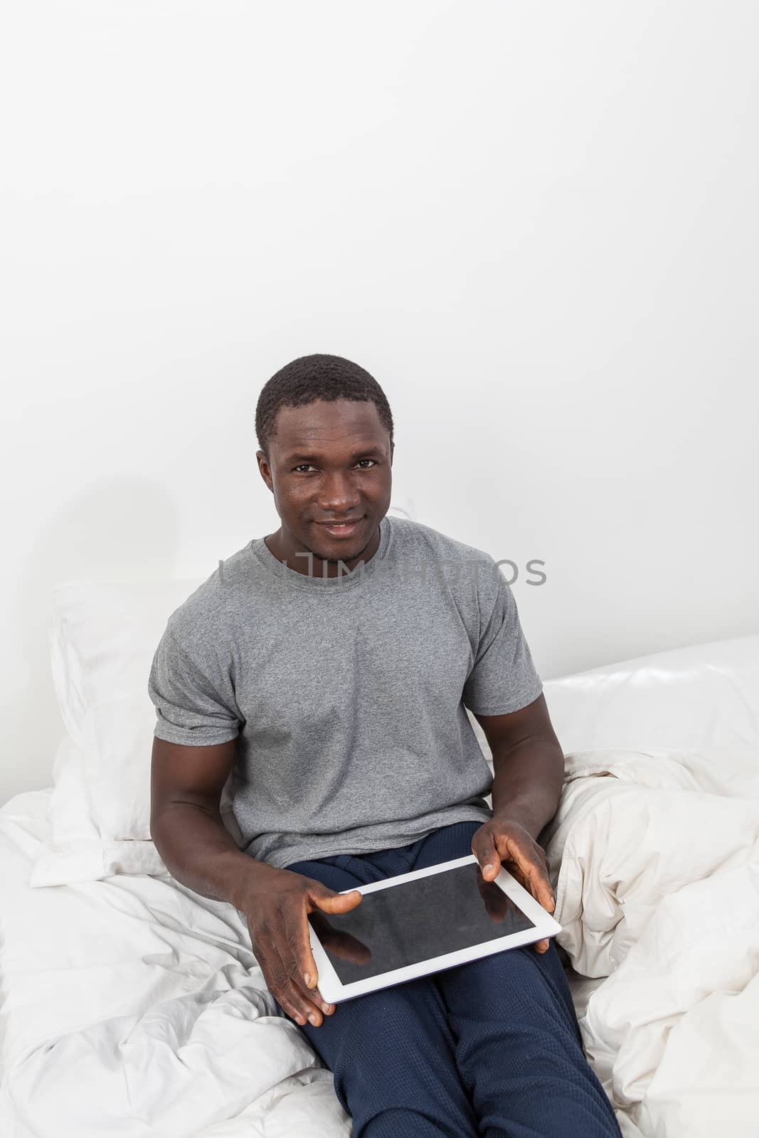 Man looking at camera and touching his tablet