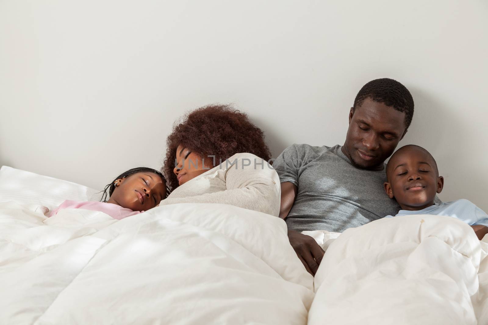 African family sleeping in the bed togehter by ifilms